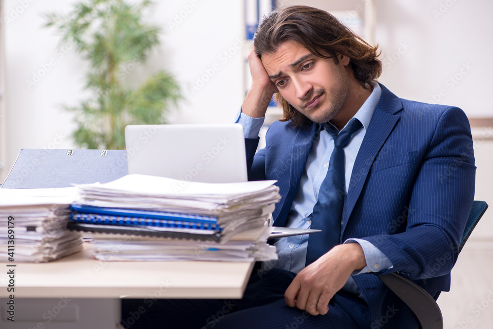 Young male employee unhappy with excessive work Young male employee unhappy with excessive work