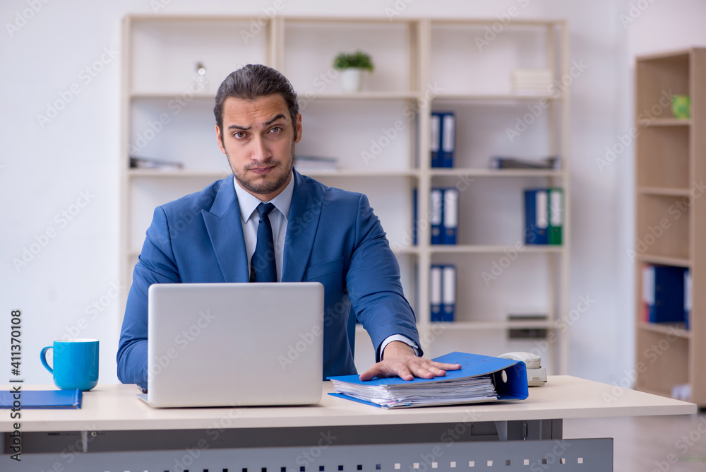 Young male employee working at workplace Young male employee working at workplace
