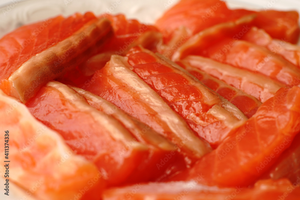 The pieces of red fish on the plate are evenly sliced. The pieces of red fish on the plate are evenly sliced.