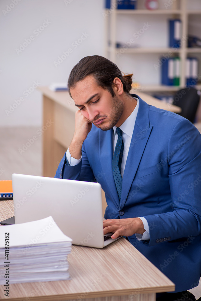 Fototapeta premium Young male employee and too much work in the office