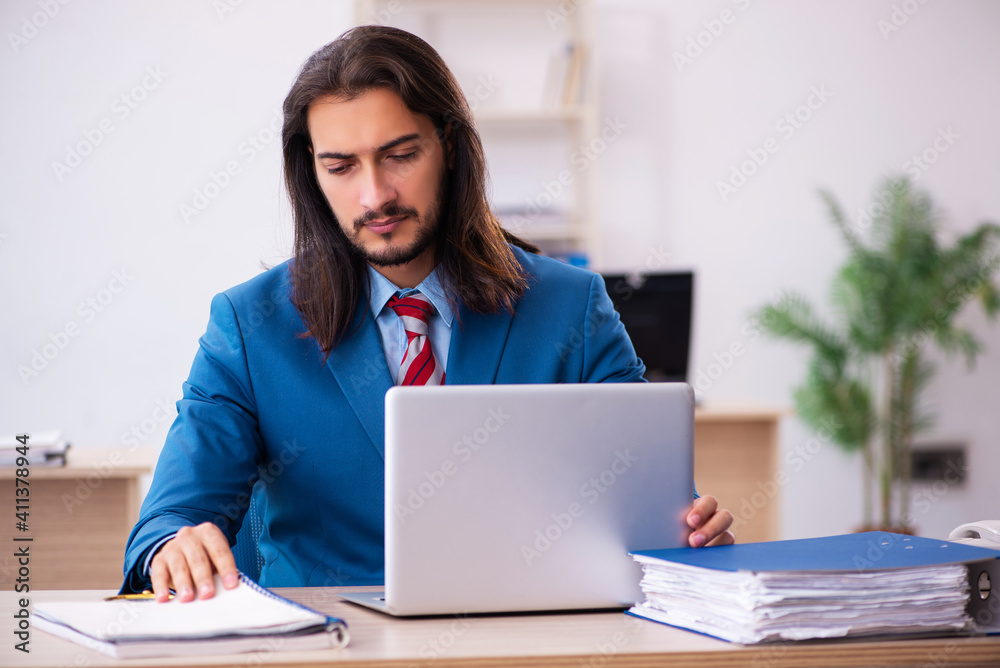 Young male employee working at workplace Young male employee working at workplace