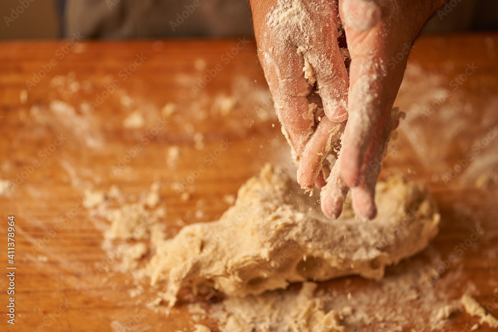 Fototapeta premium cook kneads his preparation before baking