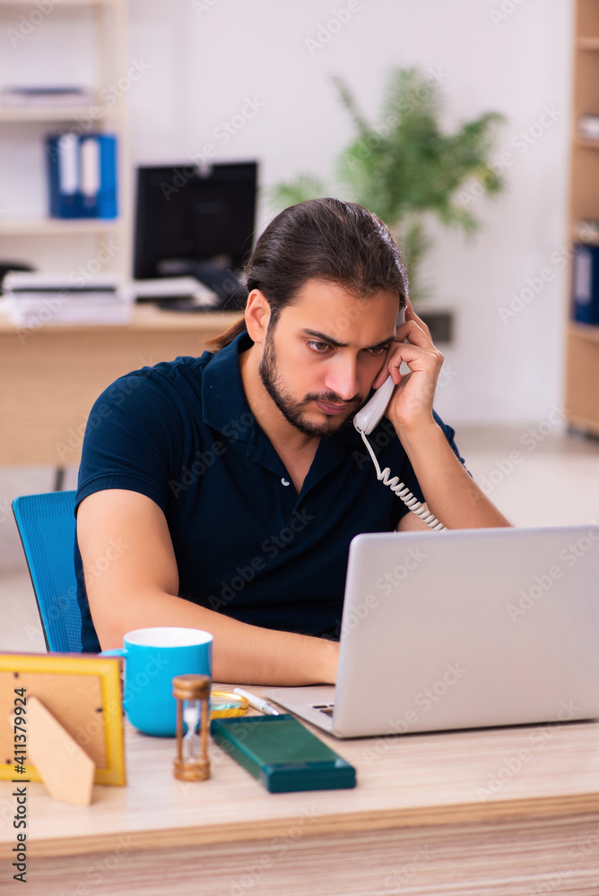 Young male employee working at workplace