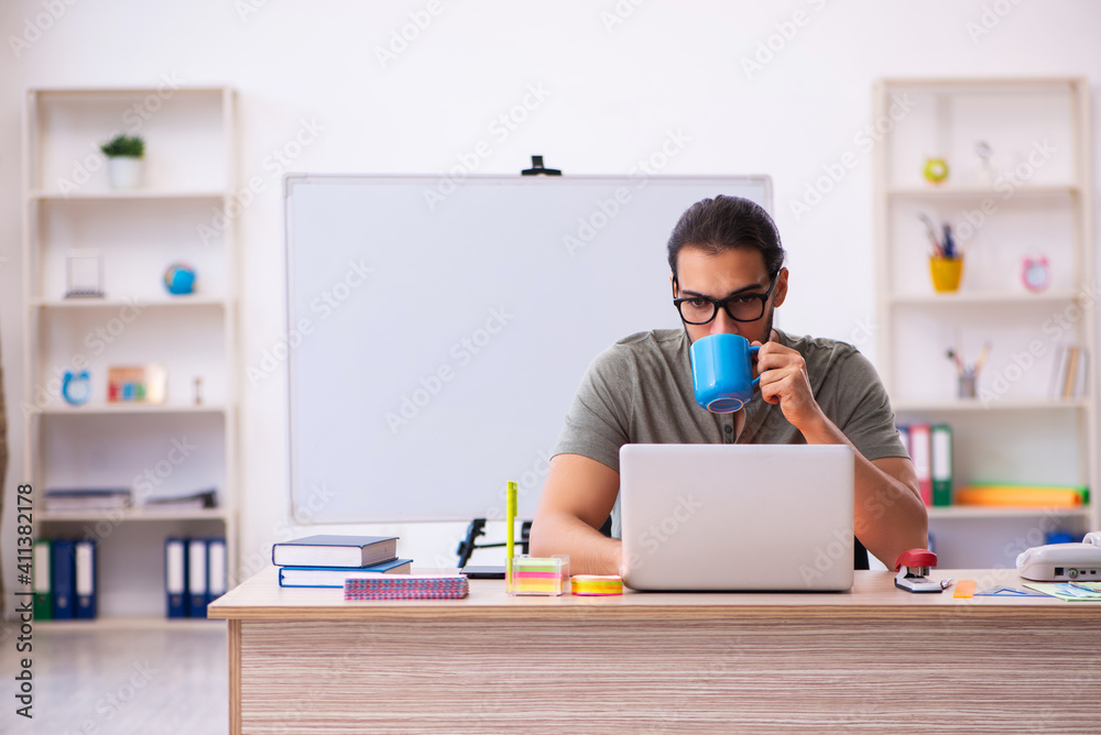 Young male designer drinking coffee in the office Young male designer drinking coffee in the office