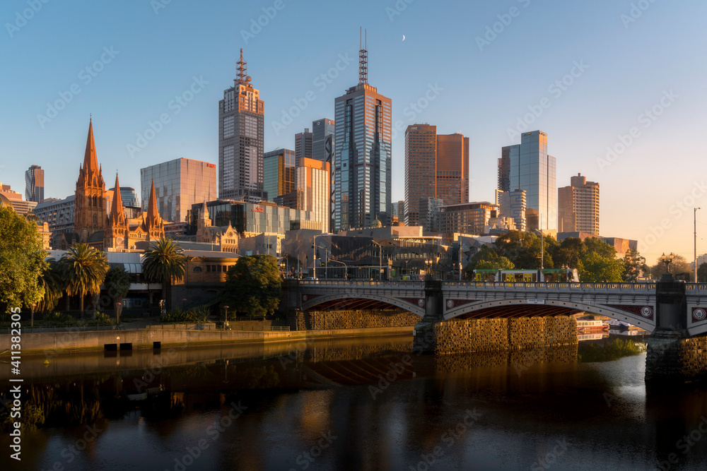 Golden light. Melbourne skyline at sunrise. Beautiful view of the city from the river bank, early morning
