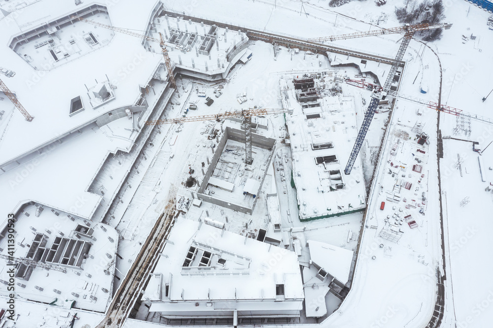 snow-covered construction site with cranes in foggy winter day. view from above with drone snow-covered construction site with cranes in foggy winter day. view from above with drone