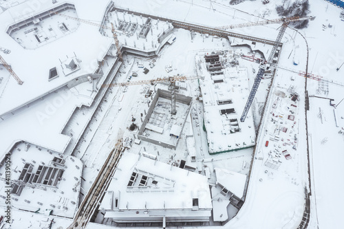 snow-covered construction site with cranes in foggy winter day. view from above with drone © Mr Twister
