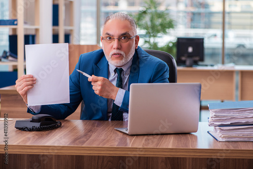 Old male employee working in the office