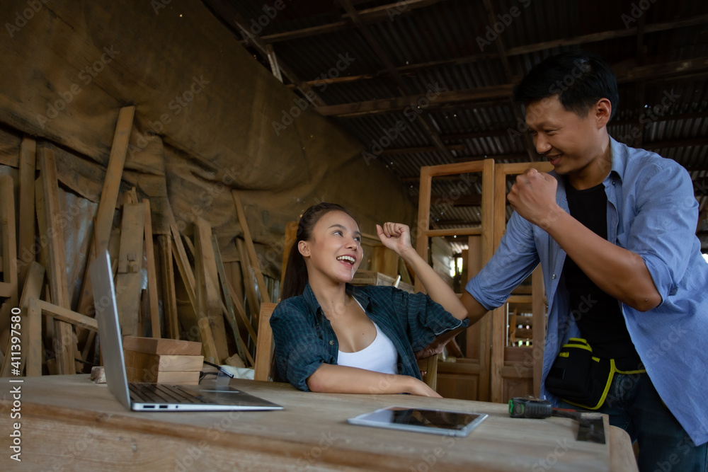Asian women and men are skilled carpenters holding a tablet, selling wood furniture online, selling things on the website Asian women and men are skilled carpenters holding a tablet, selling wood furniture online, selling things on the website
