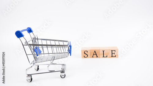 An image of trolley and wooden blocks written "SALE" isolated on a white background. Shopping concept.