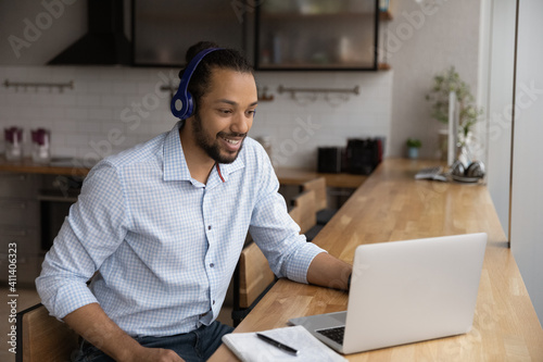 Motivated black man in headphones spend time for distant learning talk to teacher group mates on web conference. Confident biracial guy student get personal video consultation from tutor by video call