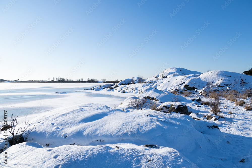 Winter landscape on sunny day, with coastline and frozen sea. Gothenburg, Sweden 020621
