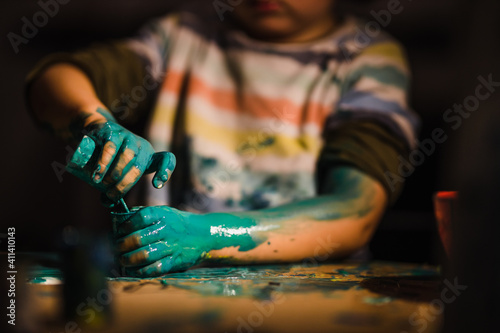 Young boy painting with colorful hands. Creativity and art , painting concept