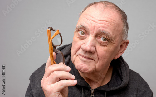 portrait vieil homme en pleine explication sur fond gris photo