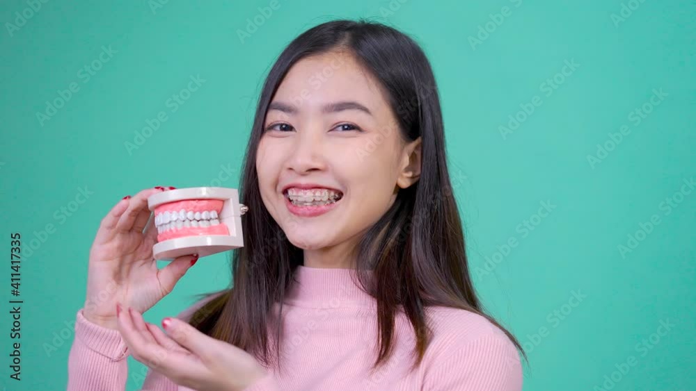 Dental of asian woman with tooth sample and white teeth increase confidence Dental of asian woman with tooth sample and white teeth increase confidence