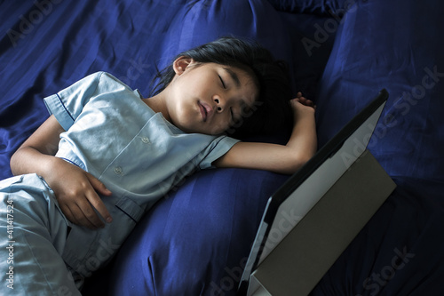 asian kids sleep on bed with laptop