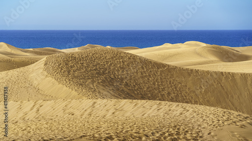 Golden sand dune desert next to the blue sea on the Canary Island of Gran Canaria  Spain. Europe