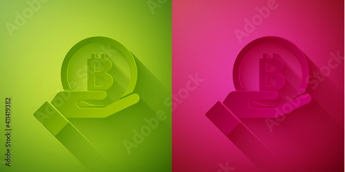 Paper cut Hand holding Bitcoin icon isolated on green and pink background. Blockchain technology, digital money market, cryptocoin wallet. Paper art style. Vector.