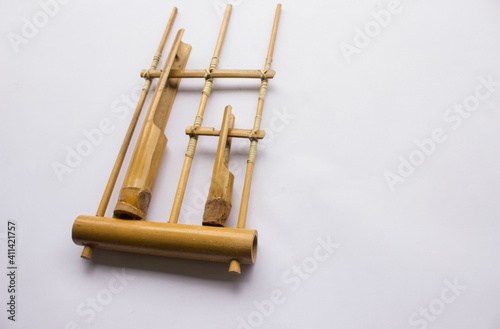 Angklung, the traditional sundanese musical instrument made from bamboo. with bamboo leaf isolated on white background