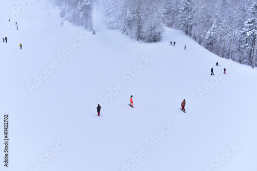 Downhill skier. Snowboarders and skier ride on snow in the mountains. Downhill ride. Adventure skiers season. Skiing and Snowboarding Resorts. Ski and snowboard equipment. Snow sports enthusiasts