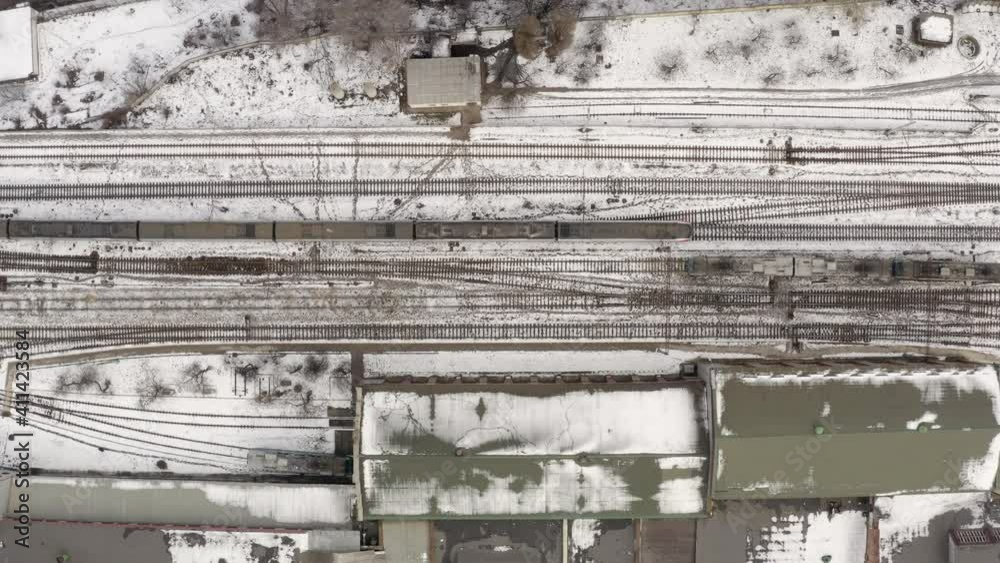 Aerial view of high-speed train. Electric locomotive with cars or railway wagon rides on railroad. Train Station Aerial Drone. highspeed train aerial top down view Aerial view of high-speed train. Electric locomotive with cars or railway wagon rides on railroad. Train Station Aerial Drone. highspeed train aerial top down view
