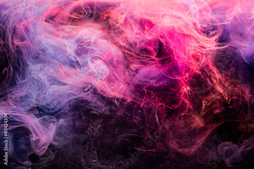 Color smoke background. Fume texture. Ink in water explosion. Passion spell. Glowing vibrant magenta pink violet vapor mix on dark.