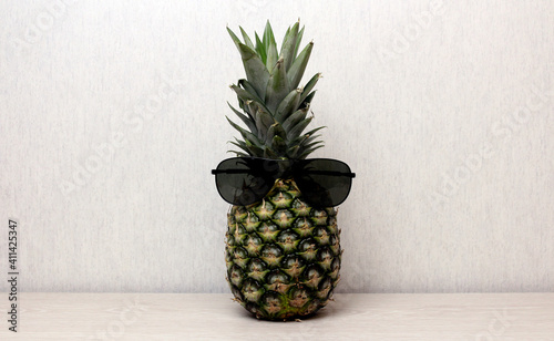 Pineapple in sunglasses on a light background