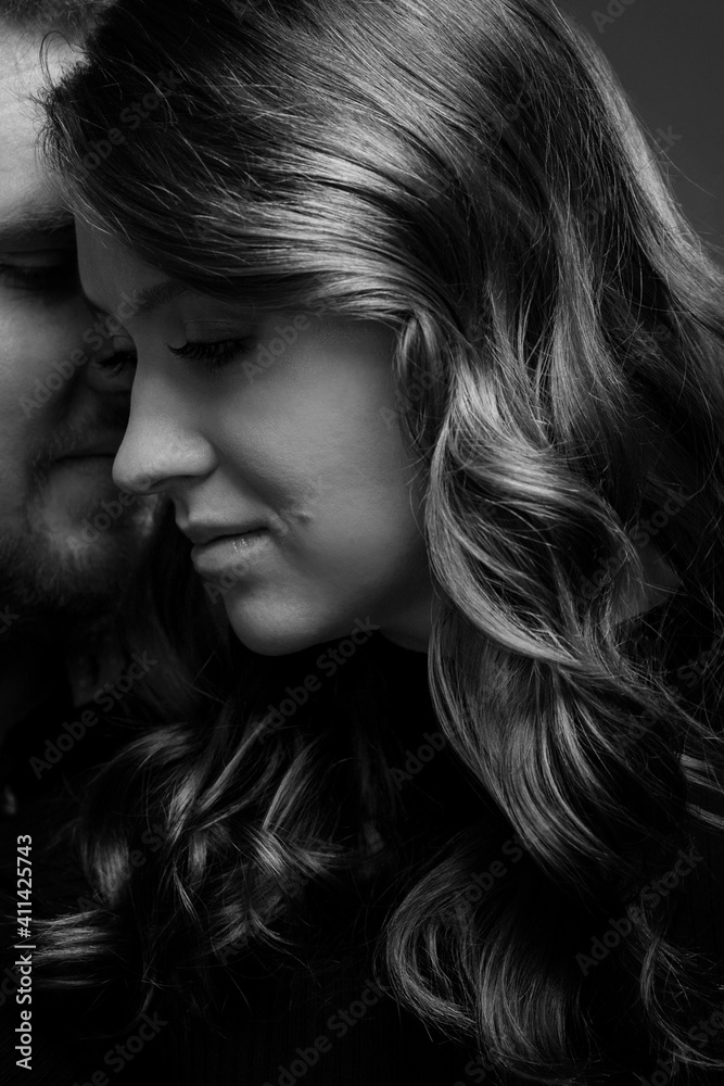 Young couple embrace tenderly and sensually. Black and white photo. Vertical. Close-up.