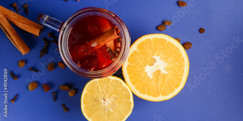Homemade honey, cinammon and lemon tea in mason jar over blue background.