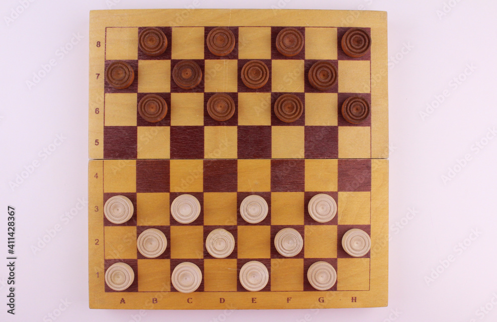Thinking game. A game for two. Wooden old checkers on a cell board. Strategy game Thinking game. A game for two. Wooden old checkers on a cell board. Strategy game
