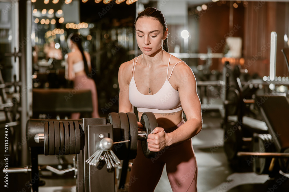 Young beautiful caucasian fit strong woman is doing exercises in gym Young beautiful caucasian fit strong woman is doing exercises in gym