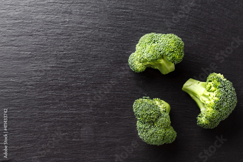 Fresh broccoli on a black cutting board. Healthy food concept.