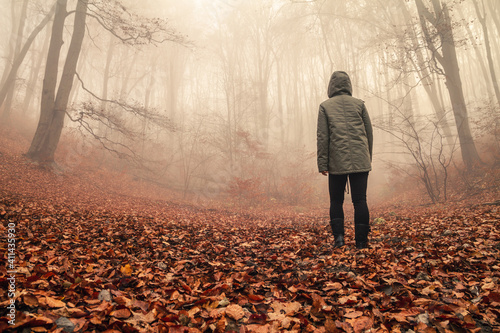 Girl walking through the foggy autumn forest. © Longfin Media
