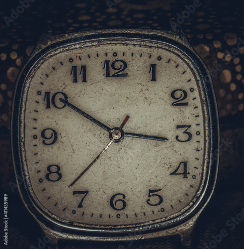 Vintage grunge background of an old clock. Abstract texture covered with dust, dirt, scratches. Macro photography in light tinted