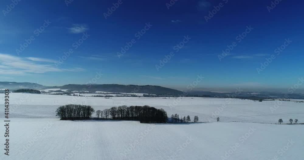Fields and forests in winter aura. A peaceful drone flight shows the beauty of winter and the blue sky Fields and forests in winter aura. A peaceful drone flight shows the beauty of winter and the blue sky