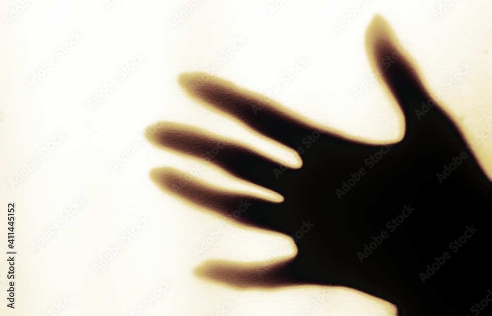 a blurred shadow of a hand on a painted wall, the shadow of a woman's hand
