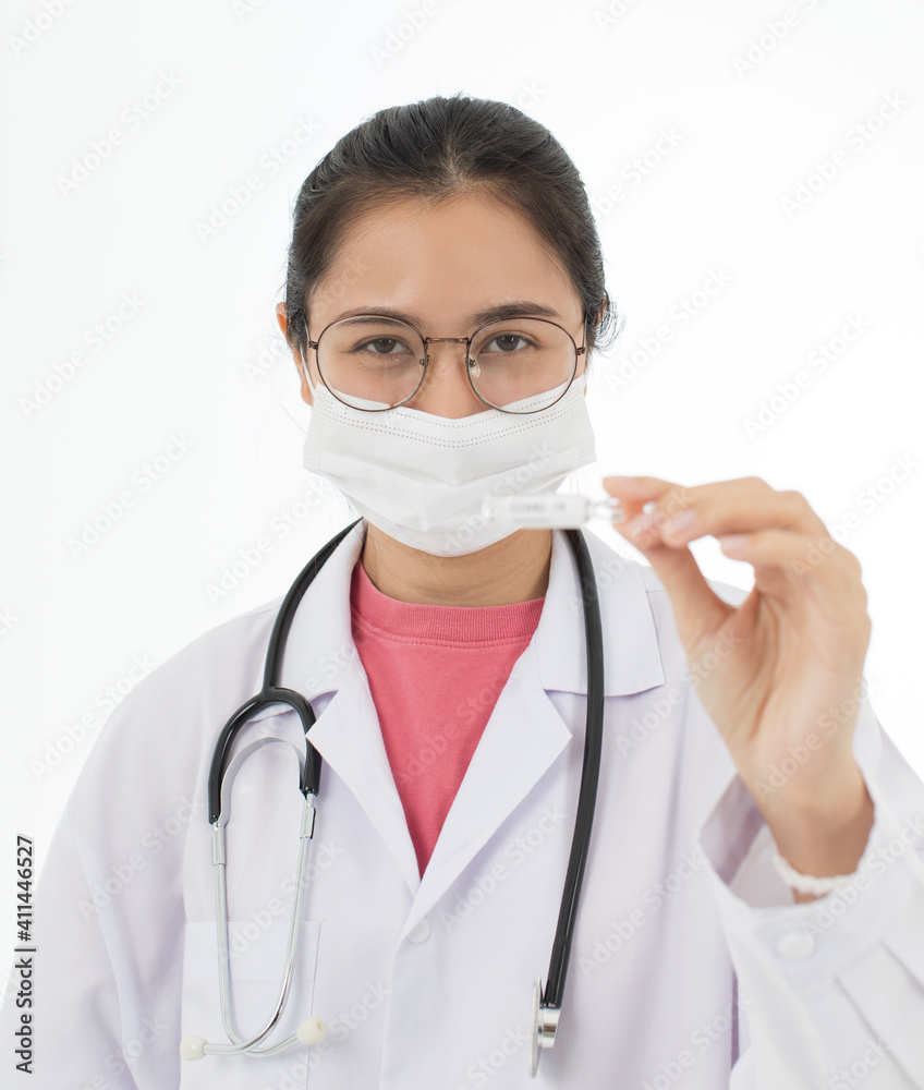 Portrait of Asian female doctor in white gown coat wearing eyes glasses in white background holding bottle of coronavirus covid 19 vaccine Portrait of Asian female doctor in white gown coat wearing eyes glasses in white background holding bottle of coronavirus covid 19 vaccine