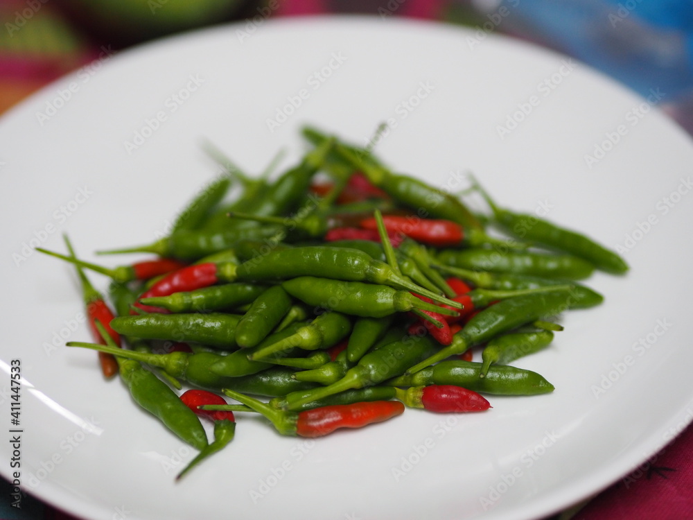 Green red Thai pepper, Chilli Padi, Capsicum annuum freshness on white plate vegetable food