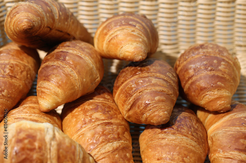 Pile of breakfast croissants. Fresh and delicious European style morning bread photographed outdoors during a sunny day. Color image.
