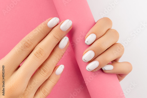 Womans hands with trendy white french manicure