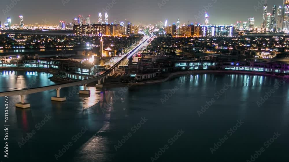 Jumeirah Palm island aerial night timelapse in Dubai, UAE. Villas, beach and monorail train top view from above. Jumeirah Palm is artificial and unique island in Dubai with skyscrappers on the Jumeirah Palm island aerial night timelapse in Dubai, UAE. Villas, beach and monorail train top view from above. Jumeirah Palm is artificial and unique island in Dubai with skyscrappers on the