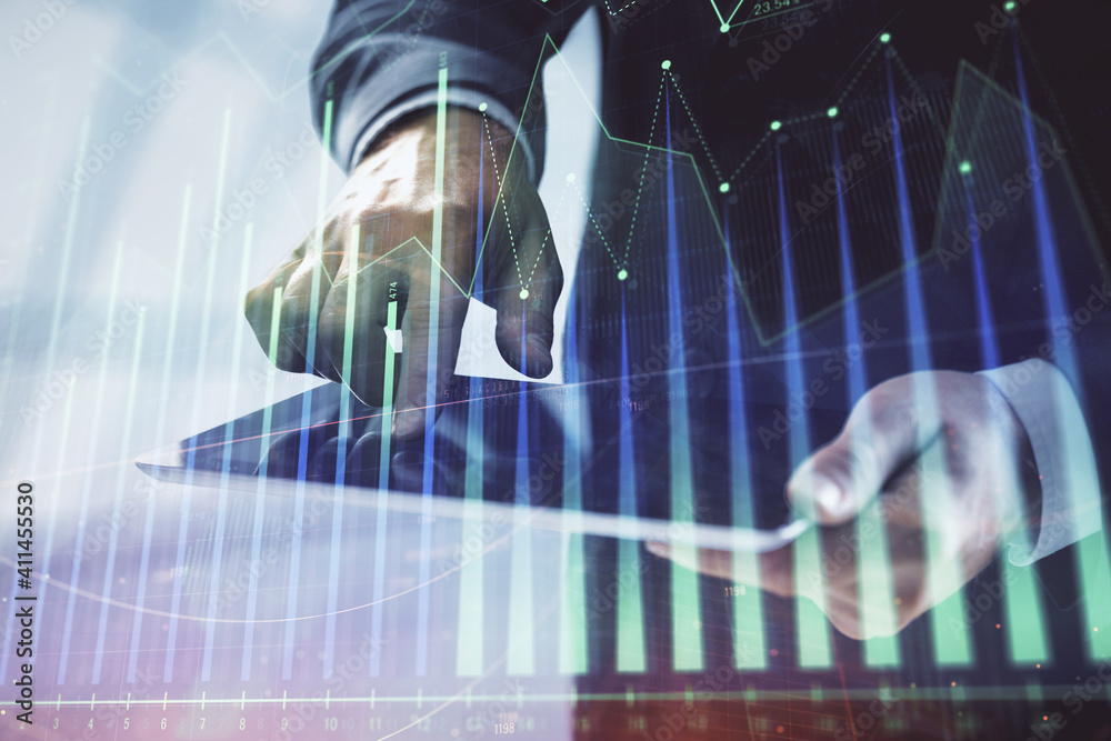 Obraz premium Double exposure of man's hands holding and using a digital device and forex graph drawing. Financial market concept.
