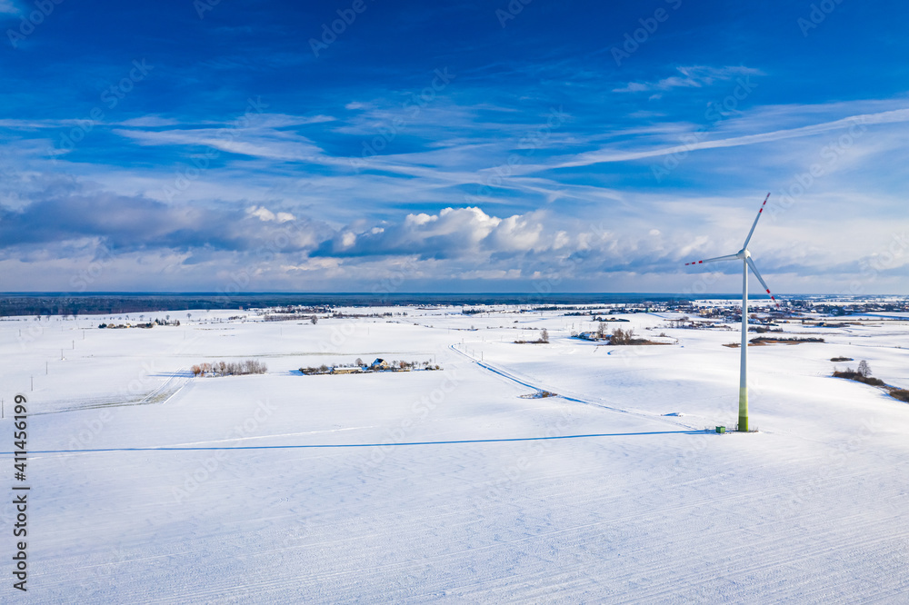 Wonderful wind turbine on snowy field in winter
