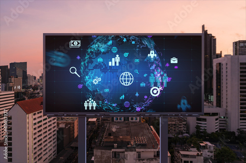 World planet Earth map hologram and social media icons on billboard over night panoramic city view of Bangkok, Southeast Asia. Networking and establishing new connections between people. Globe