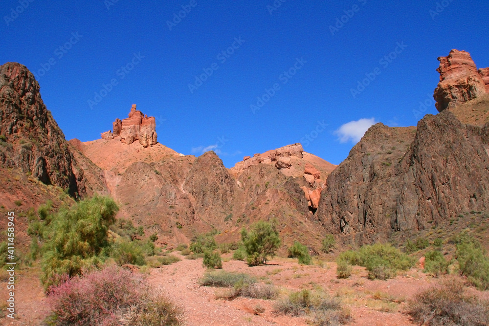 Charyn Canyon in South East Kazakhstan, summer 2019. Red rock canyon trail landscape. Trail in red rock canyon desert. Red rock canyon desert trail landscape. Yellow-red rocks of canyon in Kazakhstan.