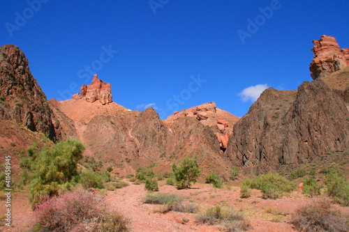 Charyn Canyon in South East Kazakhstan, summer 2019. Red rock canyon trail landscape. Trail in red rock canyon desert. Red rock canyon desert trail landscape. Yellow-red rocks of canyon in Kazakhstan.