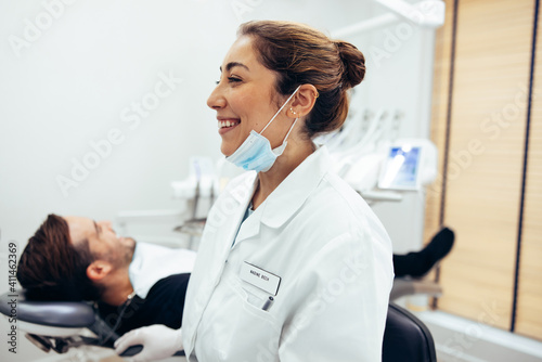 Happy female dentist in dental clinic