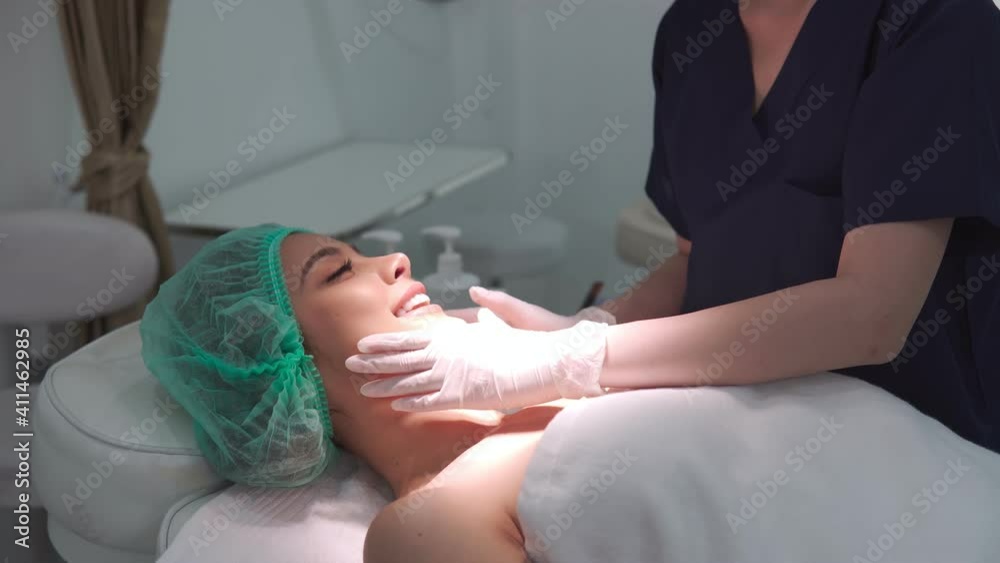Beauty clinic doctor or nurse and carefully touch a customer woman face who lie on bed and cover hair. Business concept of beauty clinic service for beauty of skin and body. Footage B roll 4k. Beauty clinic doctor or nurse and carefully touch a customer woman face who lie on bed and cover hair. Business concept of beauty clinic service for beauty of skin and body. Footage B roll 4k.