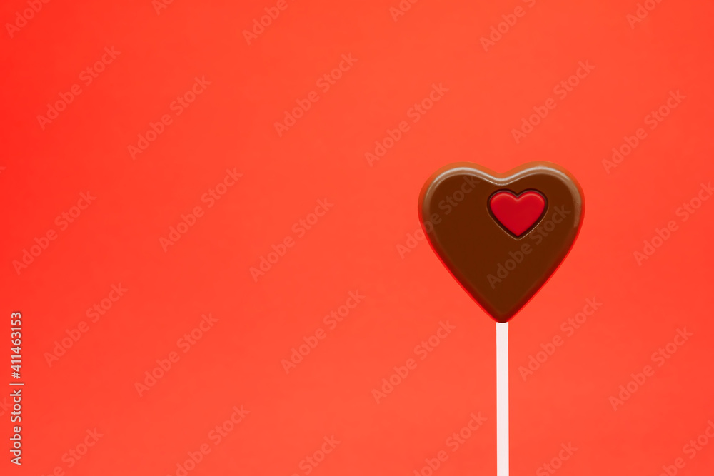 Chocolate heart on a stick. Valentine's day and love concept. Free space for text on the left. Declaration of love. celebrated on 14 February