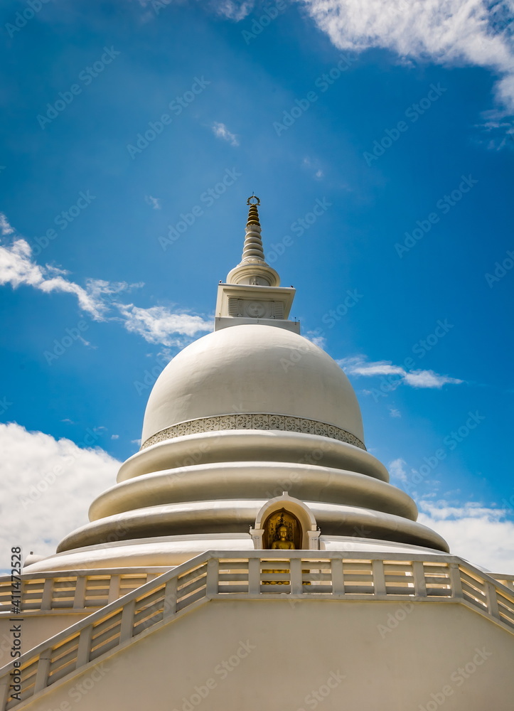 Part of a religious building close-up in Sri Lanka against a blue sky with white clouds